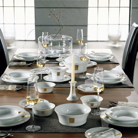 Table set with the full set of elegant white porcelain dishes with gold detailing